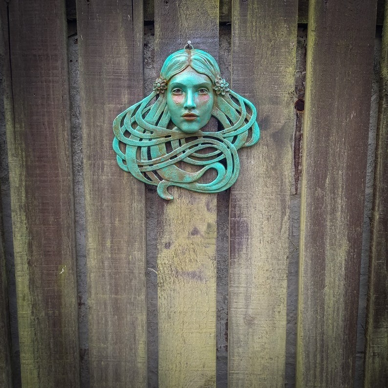 Art Nouveau inspired sculpture of beautiful female face with long stylised hair