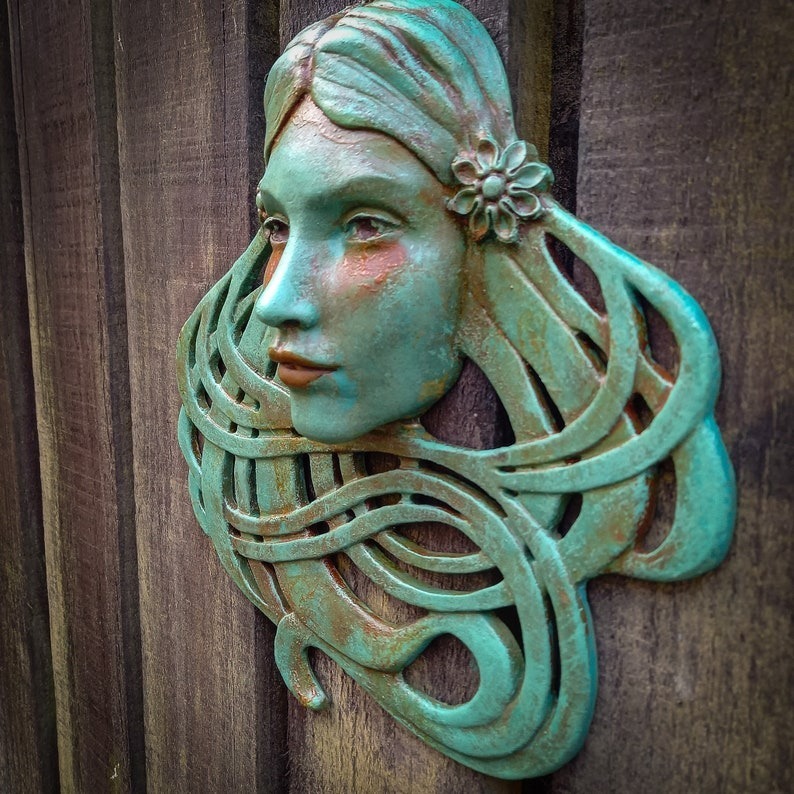 Art Nouveau inspired sculpture of beautiful female face with long stylised hair