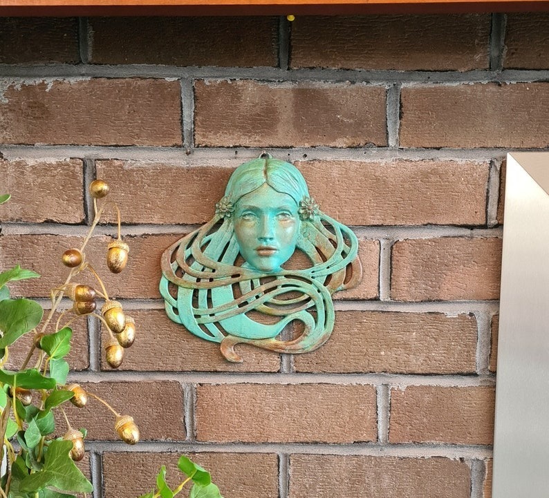 Art Nouveau inspired sculpture of beautiful female face with long stylised hair